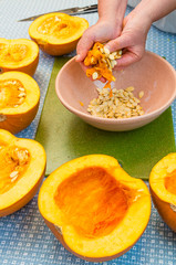 A cook extracting the seeds from a pumpkin