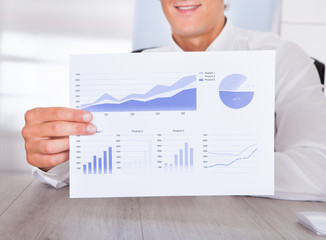 Businessman Holding Graph Printed On Paper