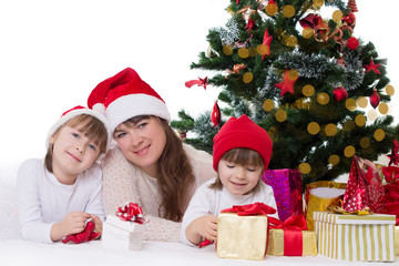 Mother and two daughters under Christmas tree