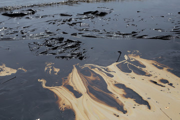 crude oil spill on the stone at the beach