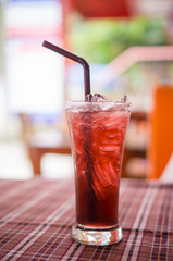 Grape juice with ice in glass at beach restaurant