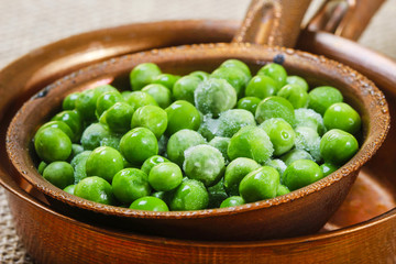 Green peas in brown iron bowl