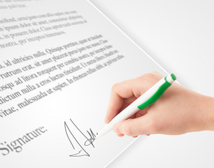 Hand writing personal signature on a paper form