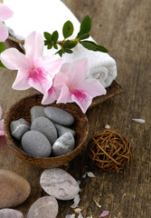 Spa concept with flower and zen stones in bowl on old wooden