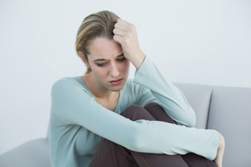 Fototapeta premium Troubled casual woman sitting on couch