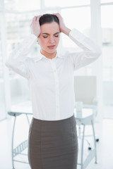 Naklejka na ściany i meble Businesswoman suffering from headache in office