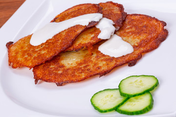 Potato pancakes with sour cream on the plate