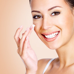 Obraz na płótnie Canvas Smiling woman applying cosmetic cream