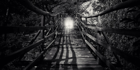 abstract black and white wooden bridge with light silhouette of man  - Powered by Adobe