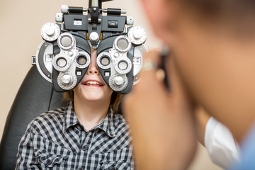 Boy Undergoing Eye Test With Phoropter