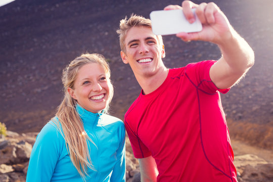 Young attractive athletic couple taking photo of themselves with