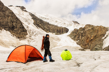 The climber costs on glacier near tent