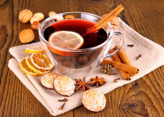 Mulled wine in glass with cinnamon stick, gingerbread and nuts