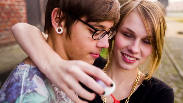 Young teenage girl and her boyfriend blowing bubbles