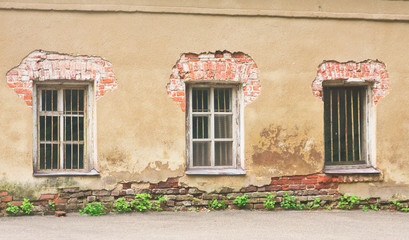 Fototapeta na wymiar Windows with bars in the old wall