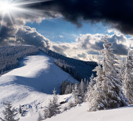 Mountain winter landscape with dark snowy clouds