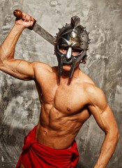 Gladiator with muscular body with sword and helmet