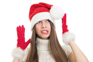 Scared surprised teenage girl wearing Santa costume looking up