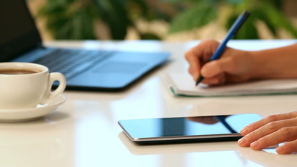 Woman hands with tablet PC and notepad at office - Powered by Adobe
