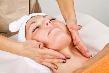 Fototapeta na wymiar Beautiful young woman receiving facial massage with closed eyes