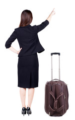 Fototapeta premium Back view of young brunette business woman traveling with suitca