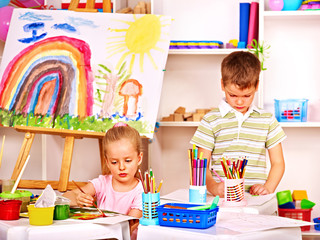 Child painting at easel.