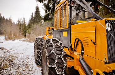 Big forest vehicle with snow chains on the wheels