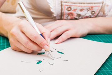 women's hand cutting flower from paper