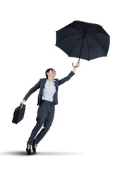 Businesswoman flying with an umbrella