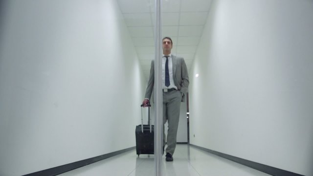 business man walking in corridoor of office building with trolle