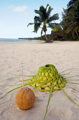 Coconut and sun hat on the sandy sea shore