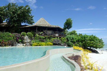 Beach bungalow and a pool in tropical pacific ocean Island.