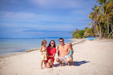 Fototapeta na wymiar Young beautiful family of four enjoyed relaxing on the beach