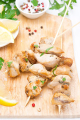 skewers of chicken with lemon and parsley on a wooden board
