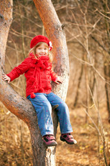 Funny little girl sitting in a tree