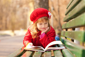 Happy smiling little girl reading interesting book © Vitalinka
