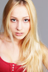 closeup portrait of a young blonde girl on gray background