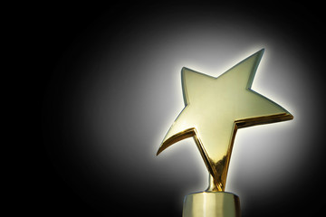 Golden star award against gradient black background