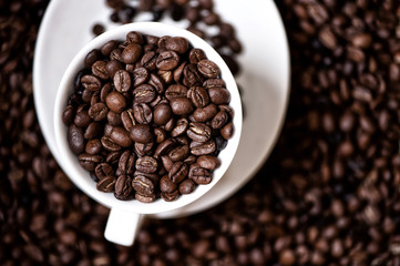 Black, strong aromatic bio african coffee beans in a coffee cup