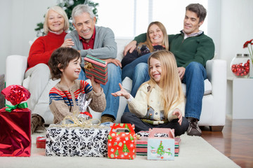 Family With Christmas Presents At Home