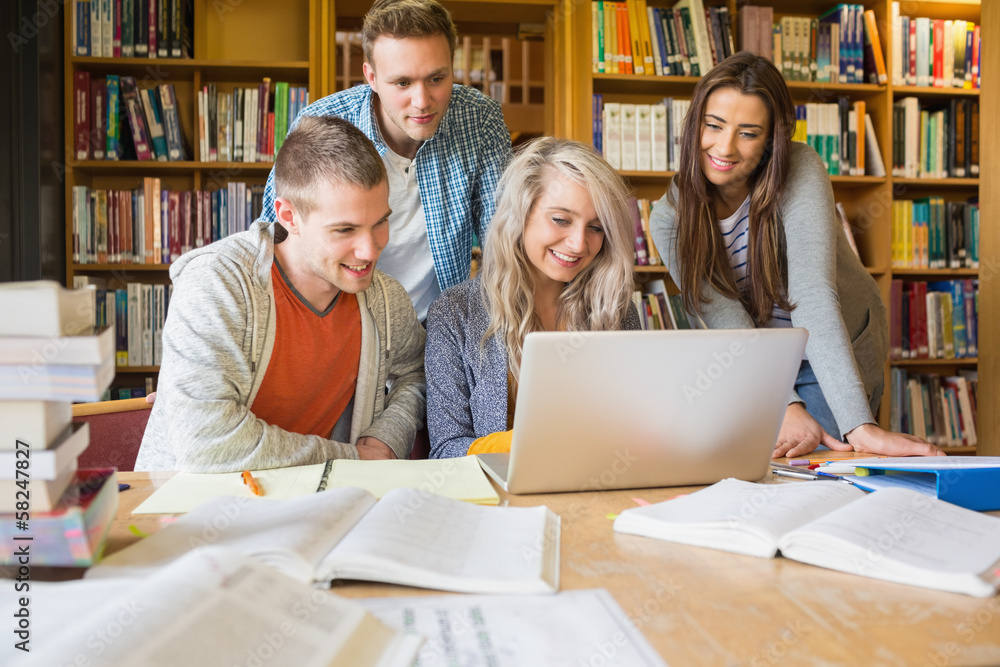 Poster happy students using laptop at desk in library