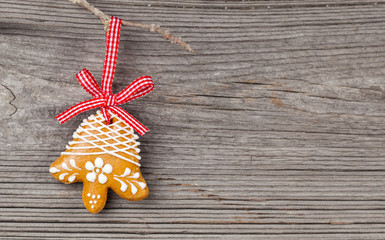 Gingerbread cookie hanging on wooden background. Christmas decor