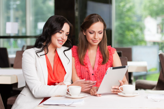 Two Female Friends Looking At Ipad.