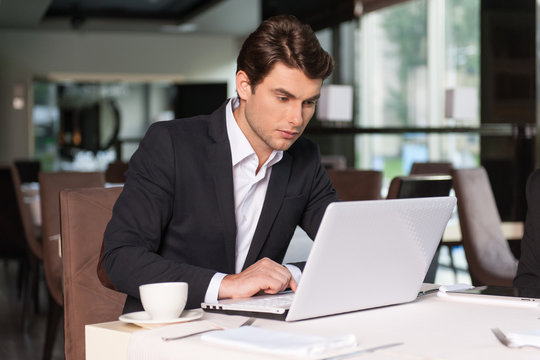 Handsome businessman working with laptop.