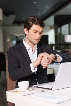 Handsome businessman looking at the watch.
