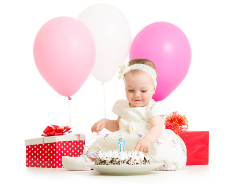 baby girl touching birthday cake