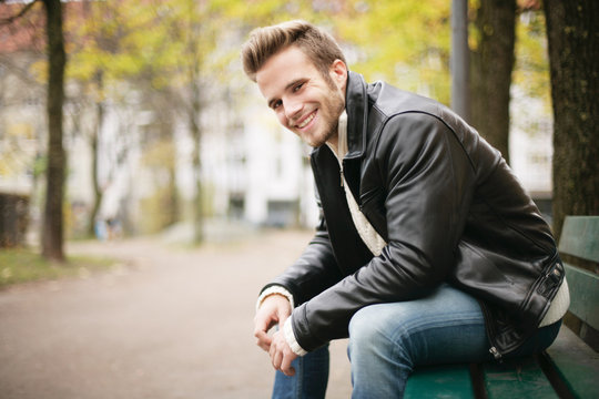 l&auml;chelnder Mann auf Parkbank