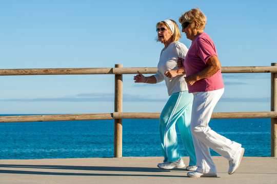 golden agers running at seafront.
