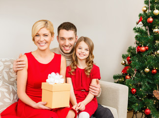 Obraz na płótnie Canvas smiling family holding gift box