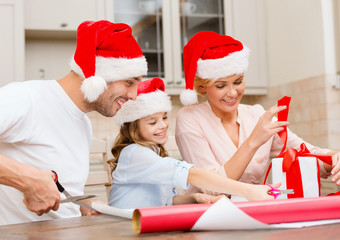 Fototapeta premium smiling family in santa helper hats with gift box